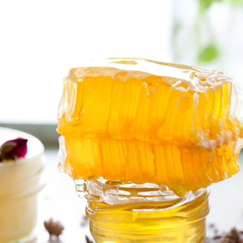 Cire d'abeille posée sur un pot de miel 